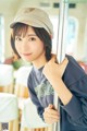 A young woman wearing a baseball cap on a bus.