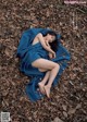 A woman laying on a blanket in the leaves.