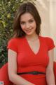 A woman in a red dress sitting on a red chair.