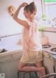 A woman sitting on a stool in a kitchen.