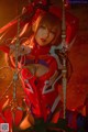 A woman in a red and white outfit is posing on a swing.