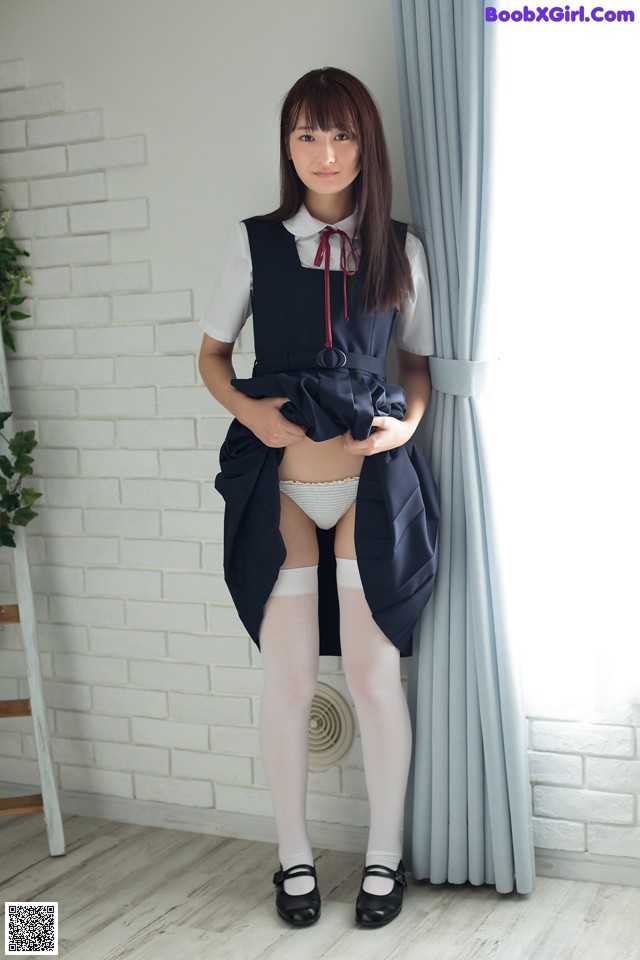 A woman in a school uniform posing for a picture.
