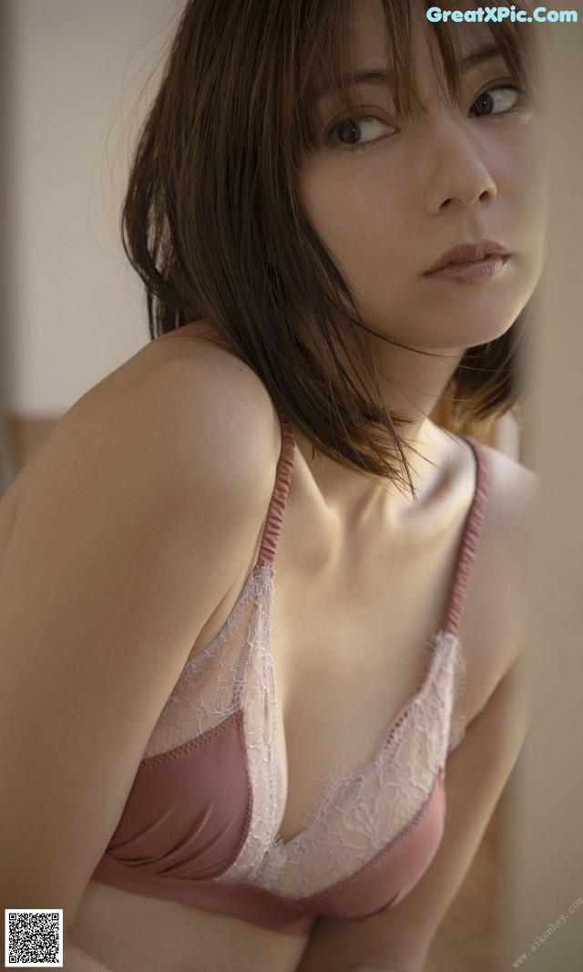 A woman in a pink bra and panties posing for a picture.